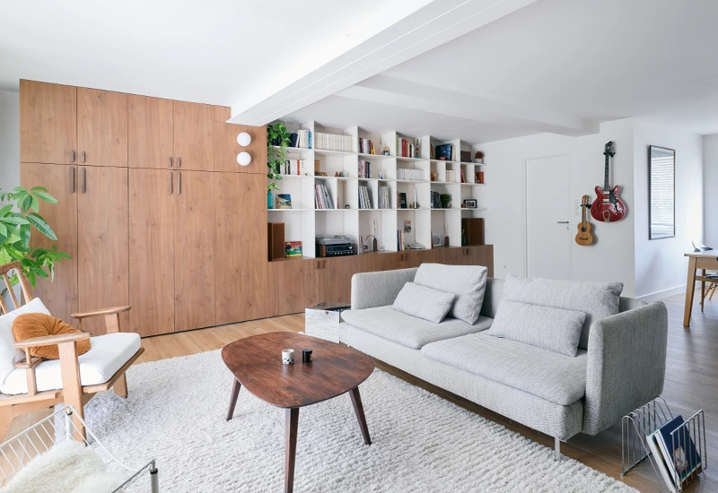 Grande bibliothèque sur mesure en bois et blanc avec bureau caché et rangements toute hauteur, conçue par Le Studio AVA